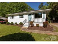 Charming home featuring a brick exterior, manicured lawn and lush, mature landscaping at 2404 Finchley Dr, Charlotte, NC 28215
