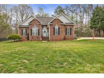 Charming brick home featuring a well-manicured lawn, an inviting entrance, and tasteful landscaping at 3565 Laboratory Rd, Lincolnton, NC 28092