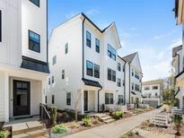 Modern townhome exterior featuring white siding, black trim, and well-maintained landscaping at 4141 Polluck Way, Charlotte, NC 28209