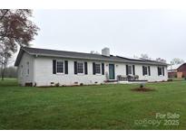 A lovely home featuring a brick exterior, black shutters, and a lush green lawn at 436 Old Nc 90 Hwy, Taylorsville, NC 28681
