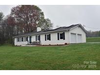 Charming white brick home with black shutters, solar panels, and a well-manicured lawn at 436 Old Nc 90 Hwy, Taylorsville, NC 28681