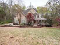 Charming two-story home with lush front lawn and inviting covered porch at 6108 Mcilwaine Rd, Huntersville, NC 28078