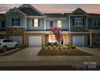 Charming townhome with a one-car garage, stone accents, and well-maintained landscaping at 7036 Heron Rookery Way, Charlotte, NC 28214