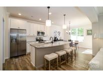 Modern kitchen with stainless steel appliances, granite countertops, and a breakfast bar at 7036 Heron Rookery Way, Charlotte, NC 28214