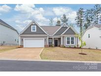 Charming one-story home featuring a two-car garage, gray siding and decorative gable accents at 7662 Tanglewood Way, Denver, NC 28037