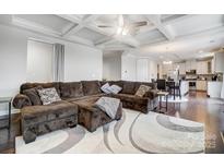 Open concept living room and kitchen with recessed lighting, coffered ceiling, and hardwood flooring at 10161 Castlebrooke Dr, Concord, NC 28027