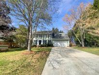 Charming two-story home featuring a manicured lawn, a long driveway, and an attached two-car garage at 1090 Briarcliff Rd, Mooresville, NC 28115