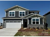 Charming two-story home featuring a two-car garage, stone accents, and a well-maintained lawn at 1440 Mccollum St, Monroe, NC 28112