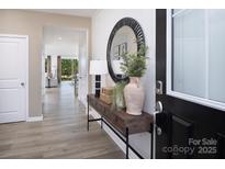 Inviting foyer with wood-look flooring, decorative table, mirror, and decor offers a warm entrance at 1440 Mccollum St, Monroe, NC 28112