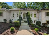 Traditional home with a painted brick exterior and professionally landscaped front yard and entry at 2915 Cross Country Rd, Charlotte, NC 28270