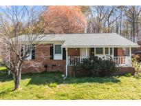 Charming brick ranch home featuring a well-maintained lawn, and cozy front porch at 394 Efird St, Gastonia, NC 28054