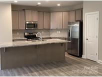 Well-lit kitchen features stainless steel appliances and granite countertops for modern cooking at 5126 Rocky River Crossing Rd, Harrisburg, NC 28075