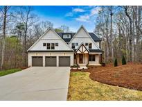 Beautiful home featuring a three-car garage, brick accents, and a well-manicured lawn at 6654 Maple Spring Ct, Denver, NC 28037