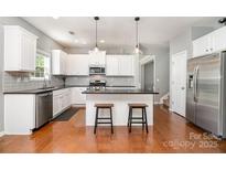 Bright kitchen with white cabinets, stainless steel appliances, and granite countertops at 9013 Gailes Dr, Charlotte, NC 28278