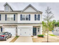 Charming townhome with a two-car garage, stone accents, and a well-maintained front yard at 10002 Brittondale Ln, Charlotte, NC 28215