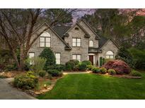 Charming brick home with manicured lawn and lush landscaping features a traditional design and inviting curb appeal at 104 Chalfont Ct, Salisbury, NC 28147