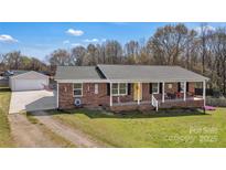 Charming brick ranch home with a cozy front porch and inviting yellow front door at 109 Connor Ct, Kings Mountain, NC 28086