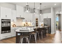 Modern kitchen with white cabinets, stainless steel appliances, and center island with bar stool seating at 1110 Sugar Creek Rd, Indian Land, SC 29707