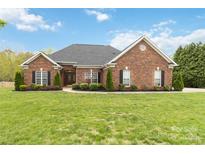 Stunning one-story red brick home with manicured lawn and beautiful landscaping at 15118 Marshall Valley Ct, Mint Hill, NC 28227