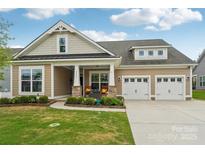 Charming home featuring a manicured lawn, inviting porch, and a convenient two-car garage enhancing curb appeal at 4004 Henshaw Rd # 448, Waxhaw, NC 28173