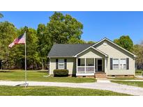 Charming single-story home with a well-maintained lawn, American flag and a gravel driveway at 4285 Palmer Lloyd Rd, Lancaster, SC 29720