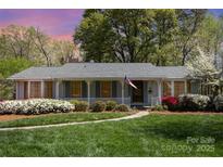 Charming single-story home with inviting front porch, manicured lawn, and lush, colorful landscaping at 726 Grandview Ne Dr, Concord, NC 28025