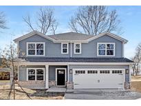 Charming two-story home with gray siding, a two-car garage, and meticulous brick-base detailing at 1034 Dooley Dr, Charlotte, NC 28227