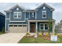Two-story home showcases a blue exterior, a two-car garage and a well-manicured front lawn at 13737 Roderick Dr # 186, Huntersville, NC 28078