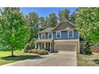 Charming two-story home with a manicured lawn, mature trees and a two-car garage at 15035 Ockeechobee Ct, Mint Hill, NC 28227