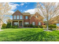 Charming two-story brick home with a manicured lawn and inviting front porch, showcasing curb appeal at 2610 Mchanna Pt, Fort Mill, SC 29708