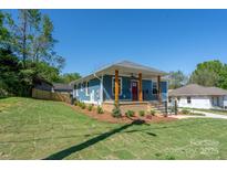 Charming blue home with a inviting front porch and beautifully landscaped front yard, perfect for curb appeal at 406 Williamson St, Fort Mill, SC 29715