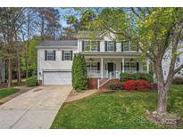 Charming two-story home featuring a welcoming front porch, colorful landscaping, and an attached two-car garage at 5225 Mcchesney Dr, Charlotte, NC 28269