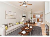 Bright living room featuring neutral tones, a dining area, and a glimpse into the well-lit, functional kitchen at 6512 Quarterbridge Ln, Charlotte, NC 28262