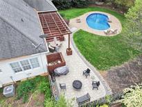 Aerial view of backyard with a patio, pergola, fire pit, and kidney-shaped pool with ample green space at 10609 Washam Potts Rd, Cornelius, NC 28031