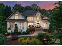 Elegant home exterior with manicured landscaping, stone walkway, and inviting entrance at dusk at 1328 Astoria Pkwy, Sherrills Ford, NC 28673