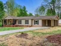 Charming single-story home with a brick foundation, vinyl siding, a covered front porch and car port at 141 Hickory Creek Dr, Gastonia, NC 28052