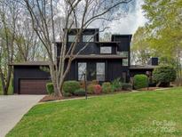 Modern two-story home with unique architectural design, a well-manicured lawn, and mature trees at 1437 Jules Ct, Charlotte, NC 28226