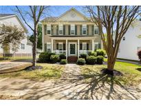 Charming two-story home with a welcoming front porch, lush landscaping, and manicured lawn at 18838 Oakhurst Blvd, Cornelius, NC 28031