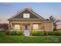 Charming home with a covered front porch, stone accents, and well-maintained landscaping at 307 Jaida Ln, Oakboro, NC 28129