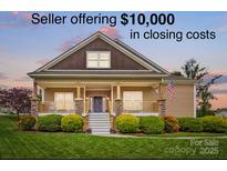 Charming one-story home featuring a covered porch, well-manicured lawn, and beautiful landscaping at 307 Jaida Ln, Oakboro, NC 28129
