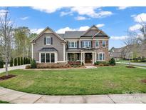 Charming two-story home featuring a beautifully landscaped yard with a mix of stone and shingle siding at 400 Eden Hollow Ln, Weddington, NC 28104
