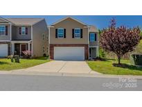 Traditional two-story home with a brick-accented front, two-car garage, and a well-maintained front lawn at 4200 Long Arrow Dr, Concord, NC 28025