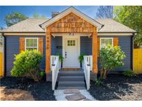 Inviting entryway with a wooden porch, stone walkway, and professionally landscaped yard at 4429 Major St, Charlotte, NC 28208