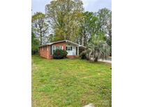 Charming brick home with a lush front lawn and mature trees at 6115 Amberly Ln, Charlotte, NC 28213