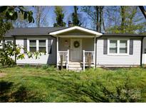 Charming single story home featuring a welcoming front porch, black shutters, and a well-maintained lawn at 6124 Old Plank Rd, Charlotte, NC 28216