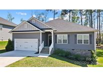 Charming one-story home with a two-car garage, gray siding, and a well-maintained lawn at 7186 Barleywood Dr, Locust, NC 28097