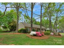 Charming one-story home with brick facade and lush front yard landscaping at 8605 Ducksbill Dr, Charlotte, NC 28277