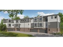 Stylish townhome showcases a two-car garage, brick accents, and a modern design with neutral colors at 8929 Sharonbrook Dr, Charlotte, NC 28210