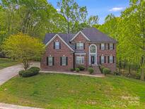 Beautiful two-story brick home with lush landscaping and a welcoming front entrance at 1000 Potters Bluff Rd, Monroe, NC 28110