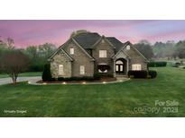 Charming, stone-accented home with manicured lawn and lush landscaping under a vibrant twilight sky at 1012 Harper Lee Dr, Newton, NC 28658